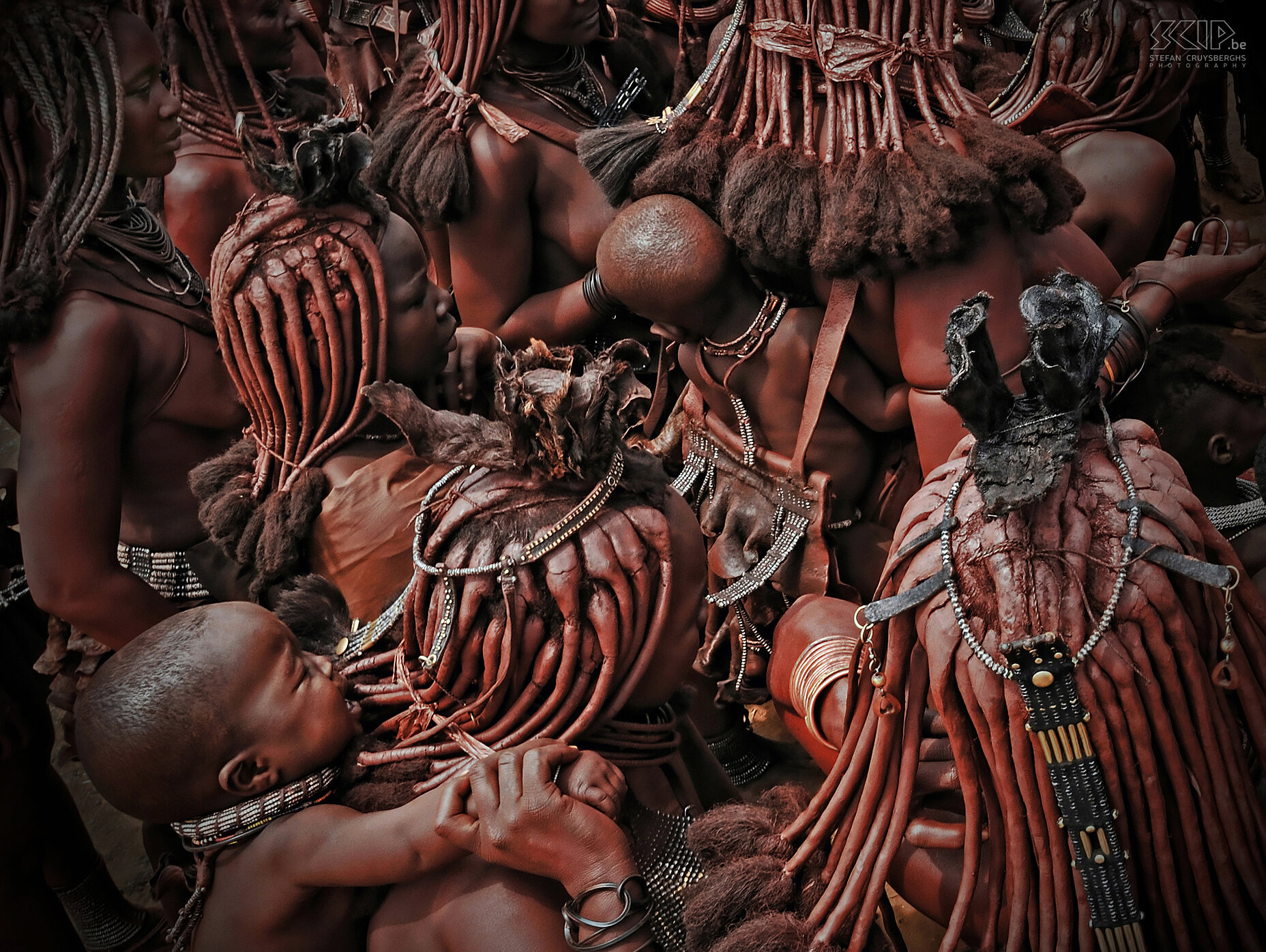 Omangete - Himba vrouwen met baby's Ik was op zoek naar een wat originele invalshoek en toen heb ik een paar foto's van bovenaf getrokken van een groepje vrouwen met hun baby's op hun rug. Je moet even moeite doen om het beeld te bekijken maar dan kan je de vele boeiende details ontdekken. Stefan Cruysberghs